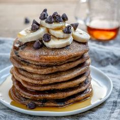 a stack of pancakes topped with bananas and chocolate chips