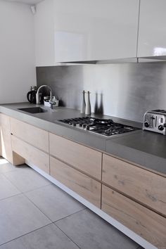 a kitchen with white cabinets and stainless steel appliances on the counter top, along with an oven