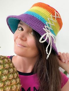 a woman wearing a colorful hat holding a pineapple