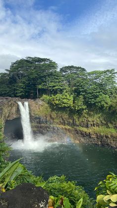 a waterfall with a rainbow in the background