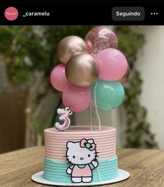 a hello kitty birthday cake with balloons on top and the number 3 in the middle