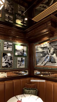 a booth with two booths and pictures on the wall above it, along with a round dining table