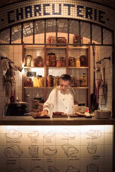 a man standing behind a counter in a kitchen