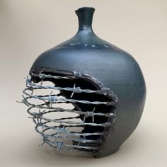 a blue vase with barbed wire in it