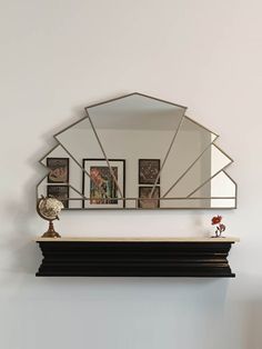 a mirror is hanging on the wall above a shelf