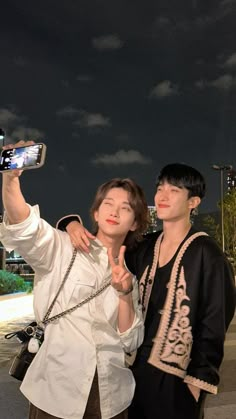 two people taking a selfie with their cell phones