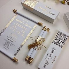 the wedding stationery is laid out on top of the table, with gold trimmings