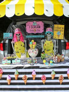 an ice cream truck with skeleton decorations on it's trunk and tables in the back