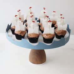 cupcakes with chocolate frosting topped with white sails