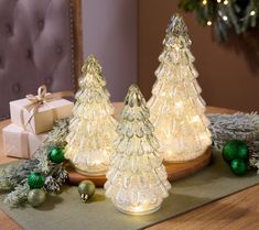 three lighted christmas trees sitting on top of a table