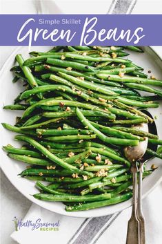 a white plate topped with green beans covered in seasoning