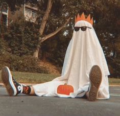 a person laying on the ground in front of a fake ghost