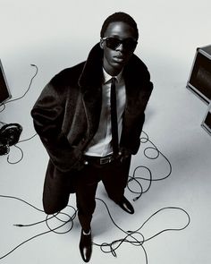 a man in a suit and tie standing next to some electronics