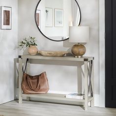 a table with a mirror, lamp and purse on it