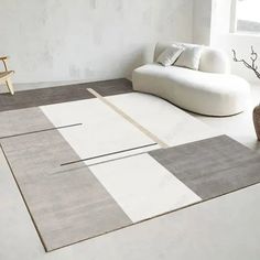 a white couch sitting on top of a rug in a living room