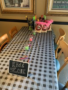 a checkered table cloth with black and white squares on it is set up for a kids zone party