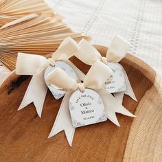 three tags with ribbons on a wooden tray