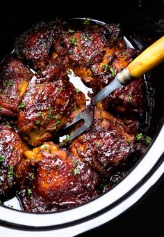 a slow cooker filled with meat and garnished with parsley