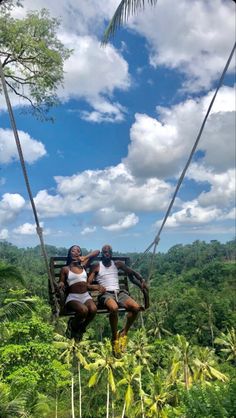 two people on a swing in the jungle