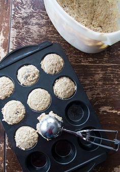 a muffin tin filled with cupcakes next to a bowl of oatmeal