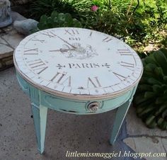 an old table with roman numerals painted on it and flowers in the background