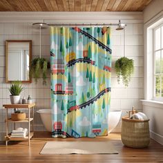 a bathroom with a shower curtain that has trains on it and trees in the background