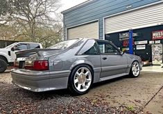 a silver car parked in front of a garage