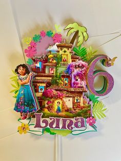 a birthday cake with the number six in front of it and a doll house on top