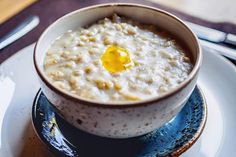 a bowl of oatmeal with an egg in it on a blue and white plate