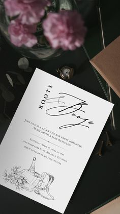 the wedding card is next to some flowers