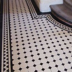 a black and white tiled floor with stairs