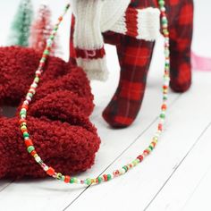 a pair of red shoes with colorful beads on them and a scarf around the ankles