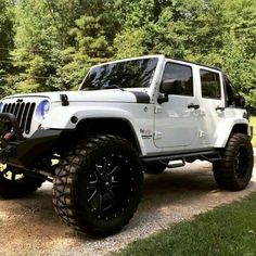 a white jeep parked on top of a gravel road