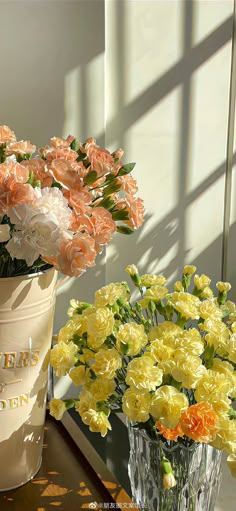 two vases filled with flowers sitting on top of a table next to each other