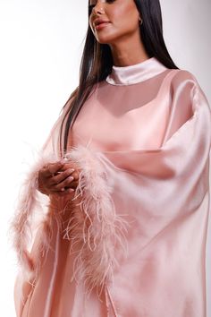 Wrap yourself in luxurious splendor with this stunning shimmer pink Organza maxi caftan dress, designed with ethereal butterfly sleeves with elegant feathers and a refined high neckline. A perfect choice for black-tie affairs, lavish resorts, wedding guests, or any occasion where timeless glamour is essential. Envision yourself gliding through a grand ballroom or strolling along an oceanfront terrace, the dress catching the light in the most alluring way. This caftan is your invitation to feel a Evening Maxi Dress With Feather Trim, Pink Long Sleeve Dress With Feather Trim, Pink Cape Sleeves Maxi Dress For Party, Pink Party Maxi Dress With Cape Sleeves, Elegant Feathered Maxi Dress, Pink Maxi Dress With Cape Sleeves For Party, Elegant Evening Kaftan With Draped Sleeves, Pink Floor-length Party Kaftan, Elegant Party Kaftan With Cape Sleeves