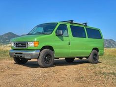 a green van is parked in the dirt