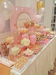 a table filled with lots of desserts and balloons