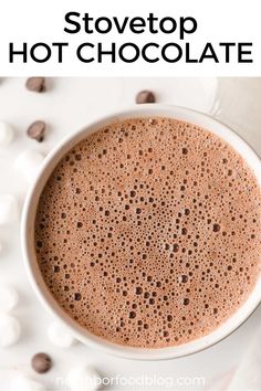 a white cup filled with hot chocolate on top of a table