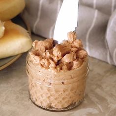 a glass jar filled with food sitting on top of a table next to donuts