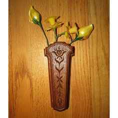 a wooden vase with yellow flowers in it