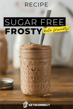 a mason jar filled with chocolate frosting on top of a wooden table