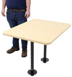 a man standing next to a rectangular table