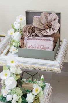 two small boxes filled with gifts sitting on top of a table