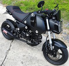 a black motorcycle parked on top of a sidewalk