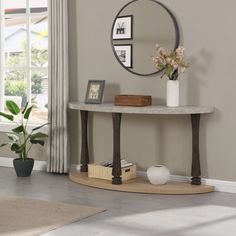 a living room with a round mirror on the wall and a table in front of it