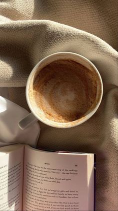 an open book and a cup of coffee on a blanket