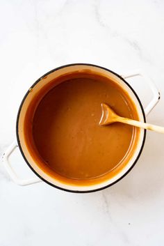 a pot filled with brown liquid and a wooden spoon in the top right hand corner