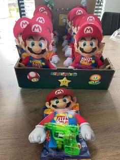 some toys are sitting on a table in front of a box with mario and luigi