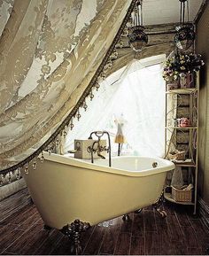 an old fashioned bathtub is in the corner of a room with curtains on it