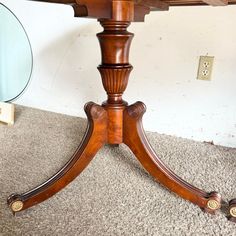 an antique wooden table with four leaves on it